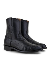 Las VAQUERO VAQUERA Arrieta - Bota de Cierre Avestruz Negro son botas vaqueras negras de media pantorrilla con puntera en punta, tacón bajo, pie de avestruz texturizado y caña de cuero liso para un look Western clásico.