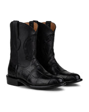 Las botas VAQUERO VAQUERA Murrieta American Alligator Negro son unas botas vaqueras negras a media pantorrilla con puntera cuadrada y sutiles costuras, fabricadas en piel de caimán americano de primera calidad y mostradas sobre un fondo blanco.