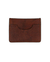 El VAQUERO VAQUERA Tarjetero De Res es un tarjetero de piel marrón con costuras visibles, un acabado texturizado y un bolsillo frontal curvado, que se muestra sobre un fondo blanco.