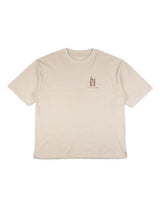 La camiseta La familia Tee de VAQUERO VAQUERA es una camiseta beige de manga corta con escote redondo y corte relajado, que presenta un pequeño gráfico y texto en el pecho izquierdo para un estilo western sin esfuerzo.