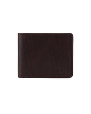 La Reserva Cafe de VAQUERO VAQUERA: cartera cerrada de piel marrón oscuro con sutiles costuras y un pequeño logotipo VA en relieve en la esquina inferior derecha, sobre fondo blanco.