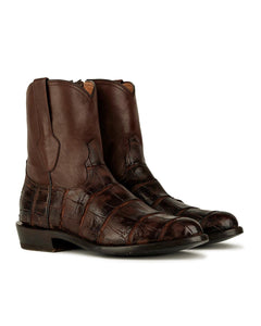 Las botas VAQUERO VAQUERA Arrieta American Alligator Caoba cuentan con auténtica piel de caimán caoba con un estampado de parches texturizados, puntera ligeramente afilada y tacón bajo en el clásico estilo de bota arrieta.