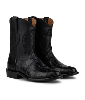 Las botas VAQUERO VAQUERA Murrieta American Alligator Negro son unas botas vaqueras negras a media pantorrilla con puntera cuadrada y sutiles costuras, fabricadas en piel de caimán americano de primera calidad y mostradas sobre un fondo blanco.