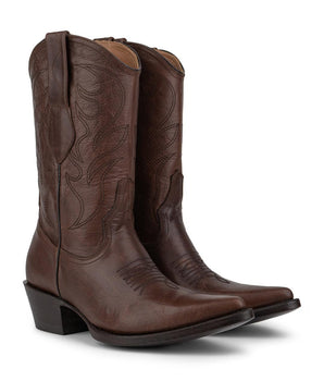 Un par de botas VAQUERO VAQUERA Santa Bárbara - Bota de Res Caoba, elaboradas en piel marrón con puntera afilada, costura decorativa en la caña y tacón angulado, se muestran una al lado de la otra y ligeramente orientadas hacia la derecha.