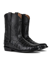 Las VAQUERO VAQUERA Murrieta - Bota de Caimán Negro presentan botas vaqueras negras con un acabado de textura de caimán, costuras decorativas y puntera en punta, mostradas sobre un fondo blanco.