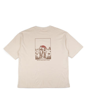 La La familia Tee de VAQUERO VAQUERA es una camiseta beige de manga corta con un gráfico en la espalda de unos ciclistas que se dirigen hacia un desierto con cactus y un sol rojo. Debajo se lee "NO HAY LUGAR COMO EL YOJANI". Una vaquera playera única y auténtica.