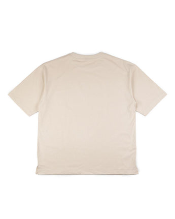 La VAQUERO VAQUERA Beige Tee, una camiseta lisa de manga corta, se presenta plana con la espalda hacia arriba sobre un fondo blanco, perfecta para looks unisex de estilo vaquero.