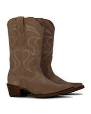 La Santa María - Bota de Gamuza Shell de VAQUERO VAQUERA cuenta con ante color canela, costuras blancas, tiras, puntera en punta y tacón de madera apilado. Estas botas para mujer se muestran con estilo una al lado de la otra, ligeramente inclinadas hacia la derecha.