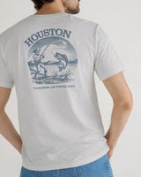 Una persona lleva una camiseta Houston Tee de VAQUERO VAQUERA de color gris claro con un pescador capturando un gran pez en la espalda, con "HOUSTON" encima, "TENEMOS UN PROBLEMA" debajo y un elegante toque western.