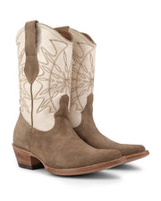 Las botas VAQUERO VAQUERA Santa Sofía Gamuza Crudo se caracterizan por su ante color canela, caña de piel color crema, costuras decorativas, tiras, puntera en punta y tacón de madera, ideales para las mujeres que buscan unas botas vaqueras elegantes y cómodas.