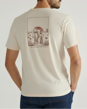 Un hombre lleva la camiseta La familia Tee de VAQUERO VAQUERA, de color crema, con una escena desértica con dos caballos y un sol rojo en la espalda. "NO HAY LUGAR COMO EL HOGAR" aparece debajo de este auténtico diseño western.